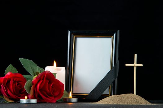 front-view-little-grave-with-flower-candles-dark